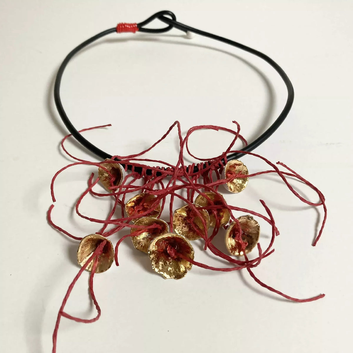 Collier cordon noir et rubans rouges, pendentifs fleurs dorées