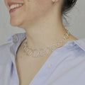 Collier à maillons ronds en métal argenté, porté autour du cou