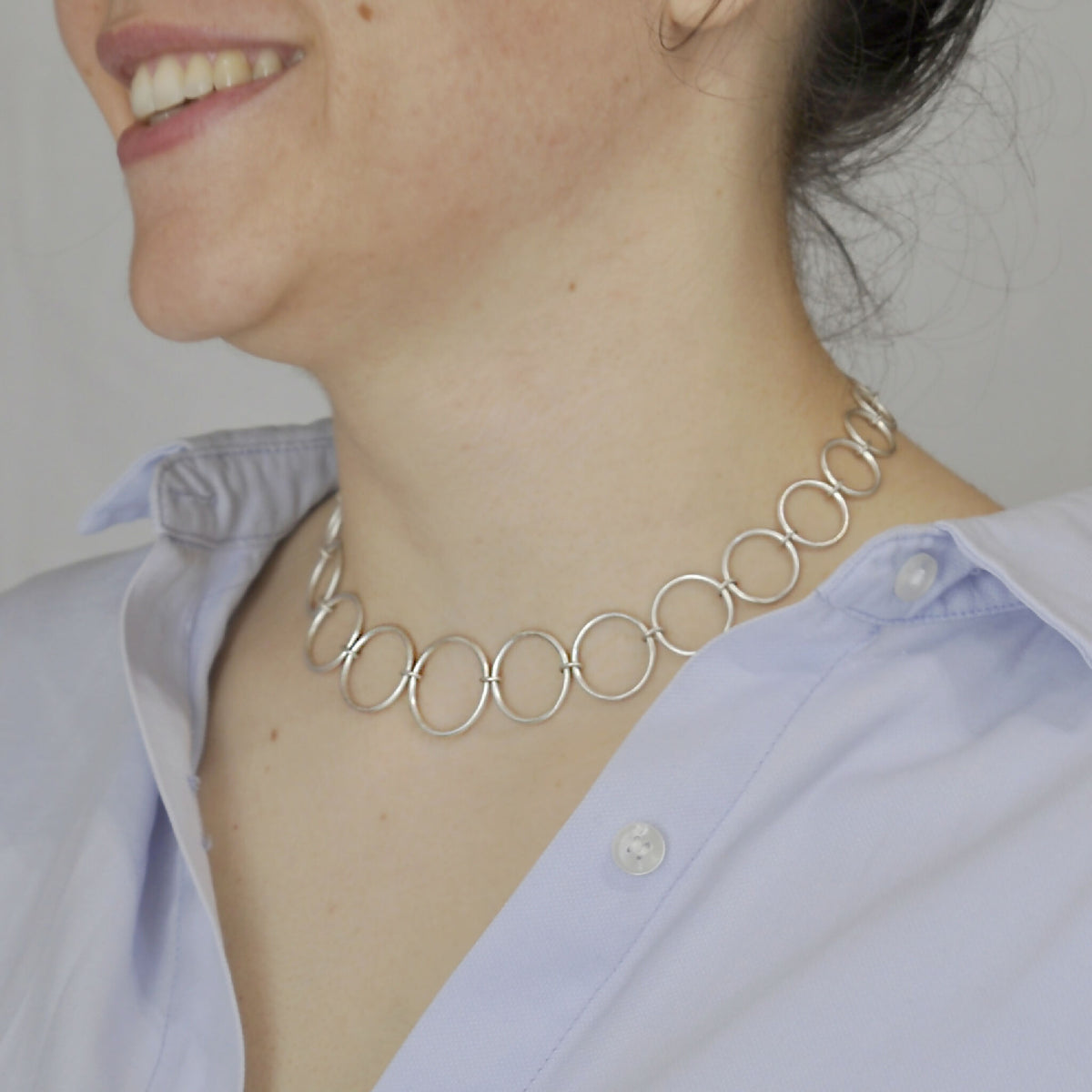 Collier à maillons ronds en métal argenté, porté autour du cou