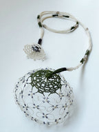Collier en soie blanc avec cordons et grand pendentif rond en dentelle.