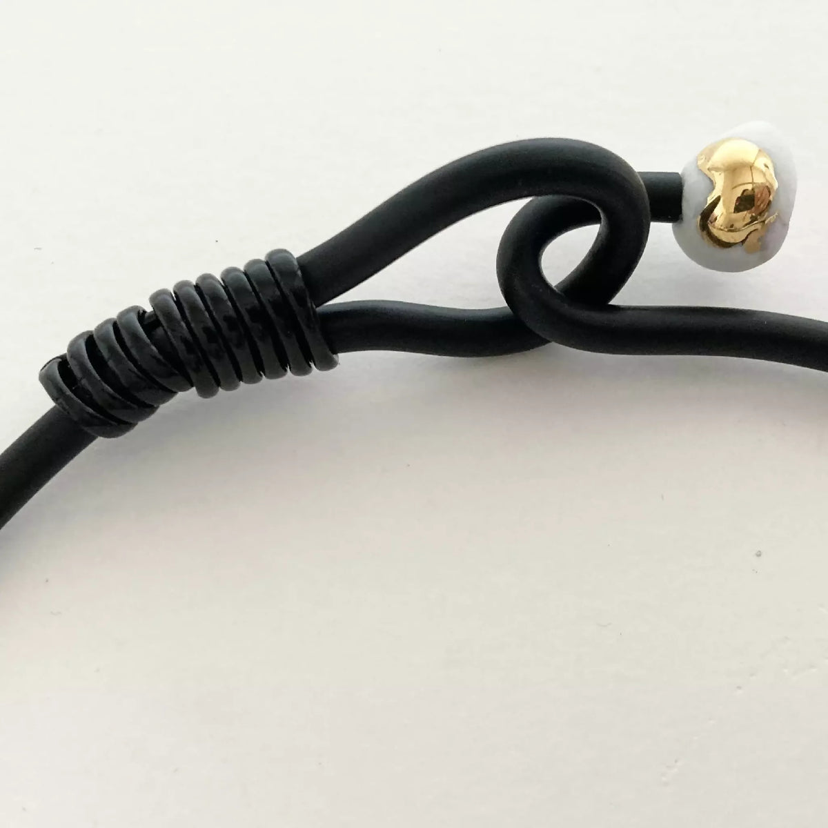Fermoir du collier en cordon noir avec perle en métal doré