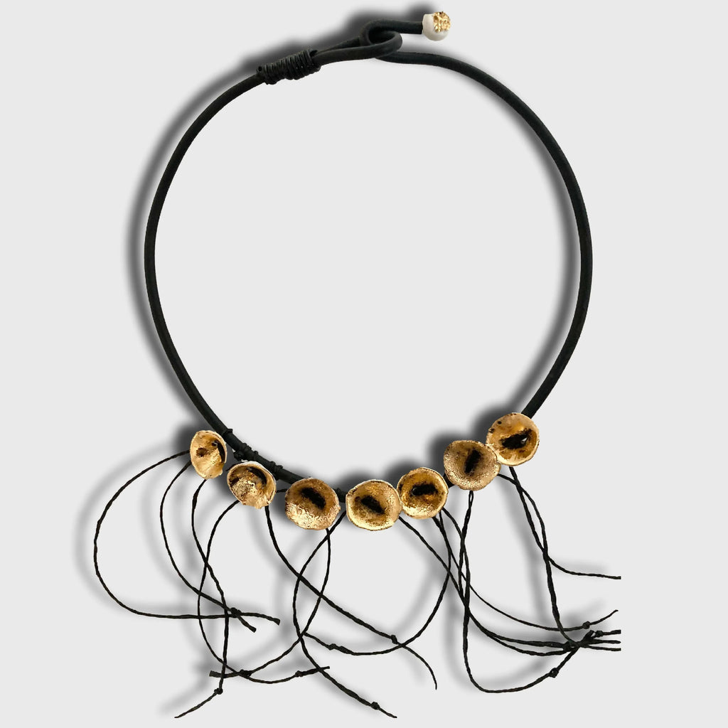 Collier noir en cordon avec disques dorés percés et petits fils noirs pendants