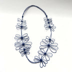 Collier de fleurs de prunier bleu en fil, fleurs enchevêtrées sur cordon souple.