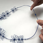 Collier de fleurs de prunier bleu : ajustement avec nœuds et boucle au col.
