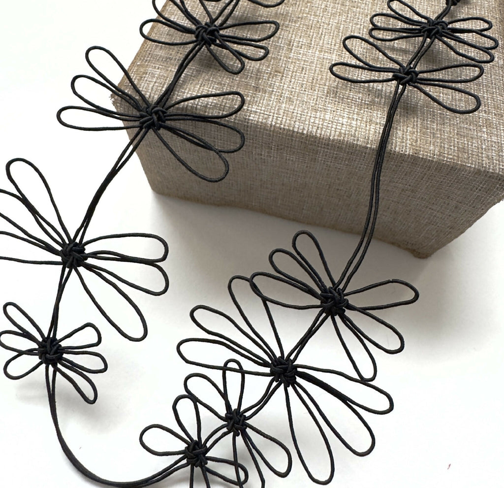 Collier de fleurs de prunier noir avec fleurs en fil noir sur cordon fin incurvé.
