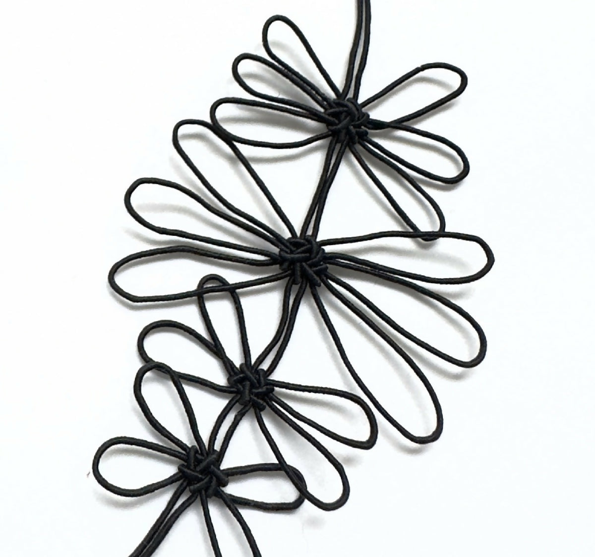 Collier de fleurs de prunier noir, gros plan de fleurs en fil aux pétales bouclés.