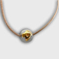 Collier en porcelaine avec pendentif goutte dorée sur cordon brun.