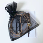 Collier en porcelaine dans un sachet en organza noir, pendentif goutte dorée.