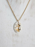 Collier en porcelaine avec médaillon ovale blanc et hirondelles dorées, chaîne dorée