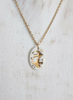 Collier en porcelaine avec médaillon ovale blanc et hirondelles dorées, chaîne dorée