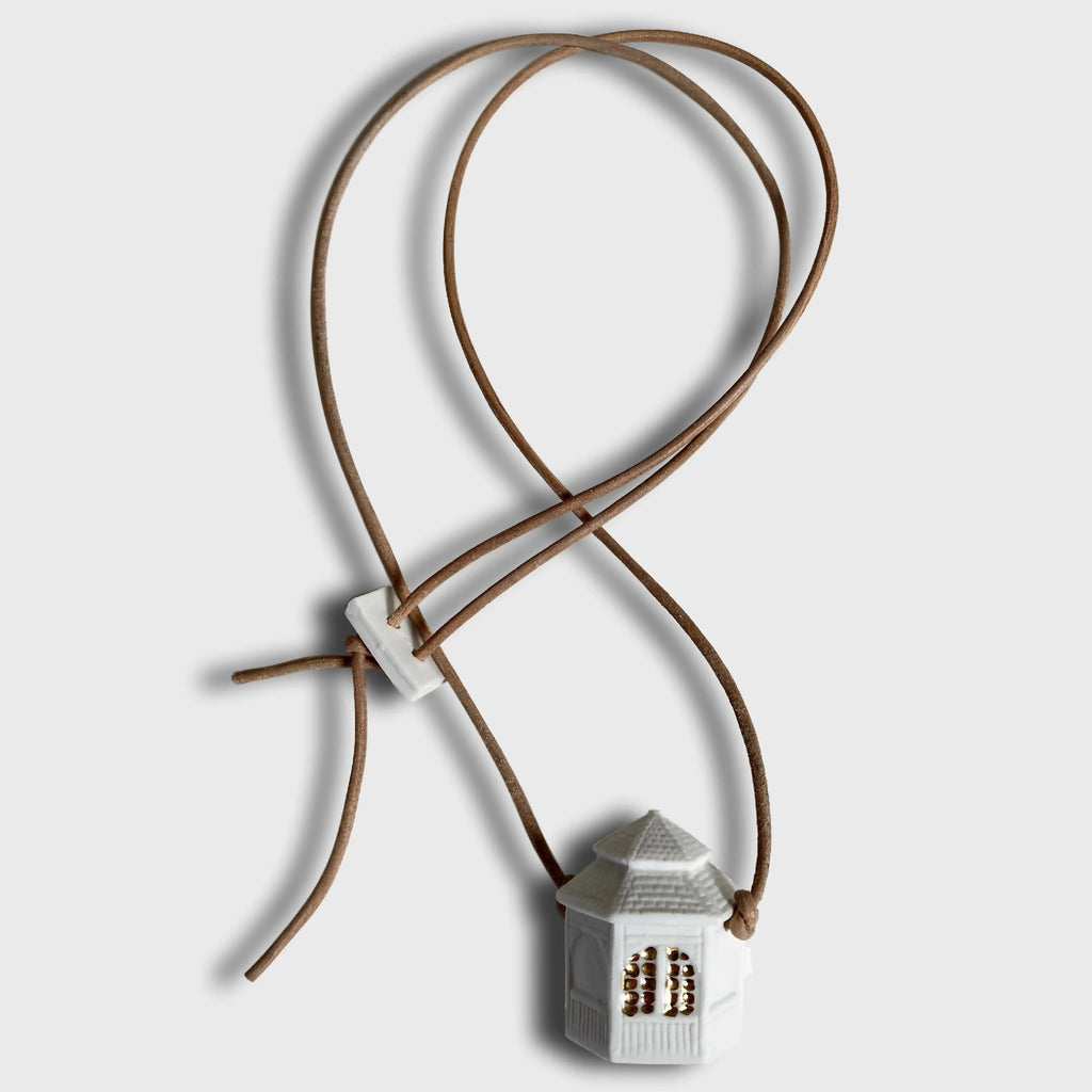 Collier fantaisie pendentif maison blanche sur cordon brun, attaches croisées