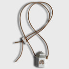 Collier fantaisie pendentif maison blanche sur cordon brun, attaches croisées