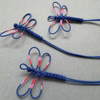 Bracelets fins bleus avec motifs de libellules rose, cordon bleu et attaches torsadées.