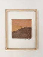 Collage textile abstrait de collines, tons terre cuite et brun foncé, cadre en bois.