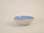 Coupe en céramique blanche à intérieur bleu, forme arrondie, bord évasé.