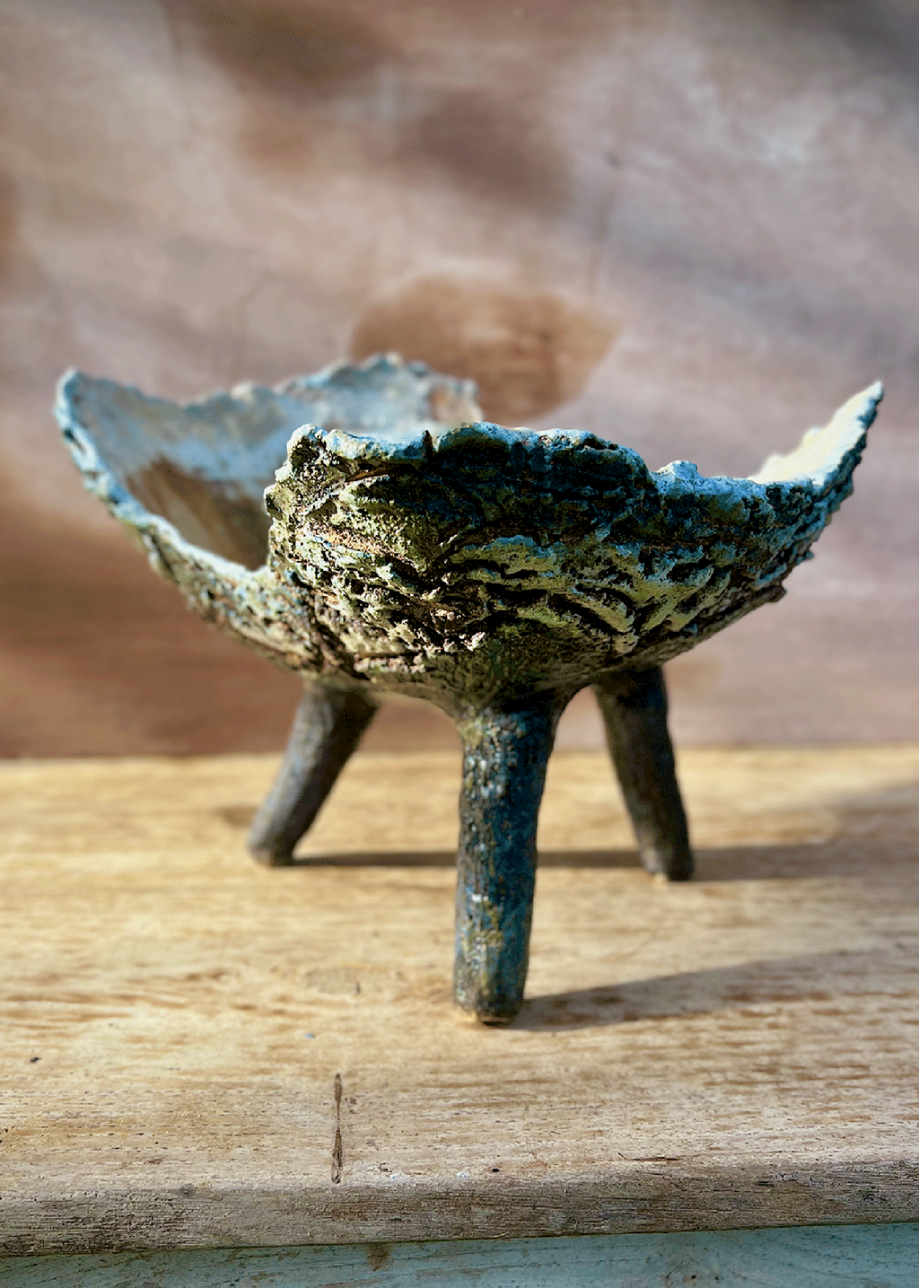 Coupe ou jardinière tripode en céramique bleu-vert, vue de face, bord ondulé et trois pieds.