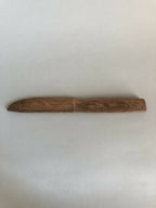 Couteau en bois taillé, lame rectiligne et manche intégré, brun, vue horizontale.