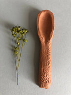 Cuillère à thé en brun cuivré, tête ovale et manche allongé.
