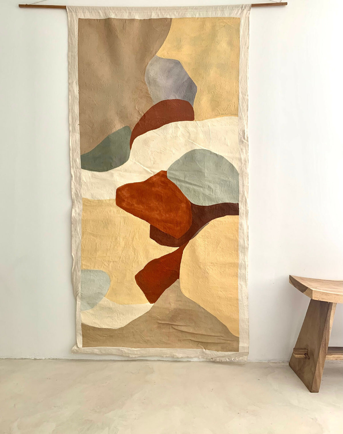 Tenture murale en tissu beige à motifs abstraits multicolores, bordure blanche