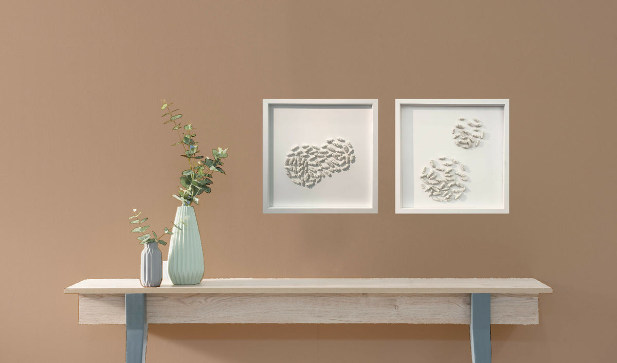 Deux petits tableaux encadrés en relief avec motifs blancs, sur console