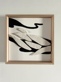 Tableau abstrait encadré, formes ondulées noir et blanc sur fond clair.
