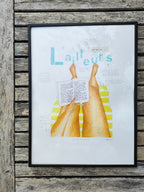 Affiche encadrée L'ailleurs avec mains colorées et texte, cadre noir.