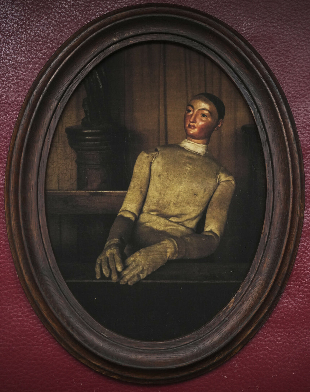 Portrait ancien ovale encadré : homme assis en tenue sombre, main posée.