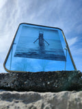 Cadre photo carré bleu avec structure au large, bord noir et attache murale