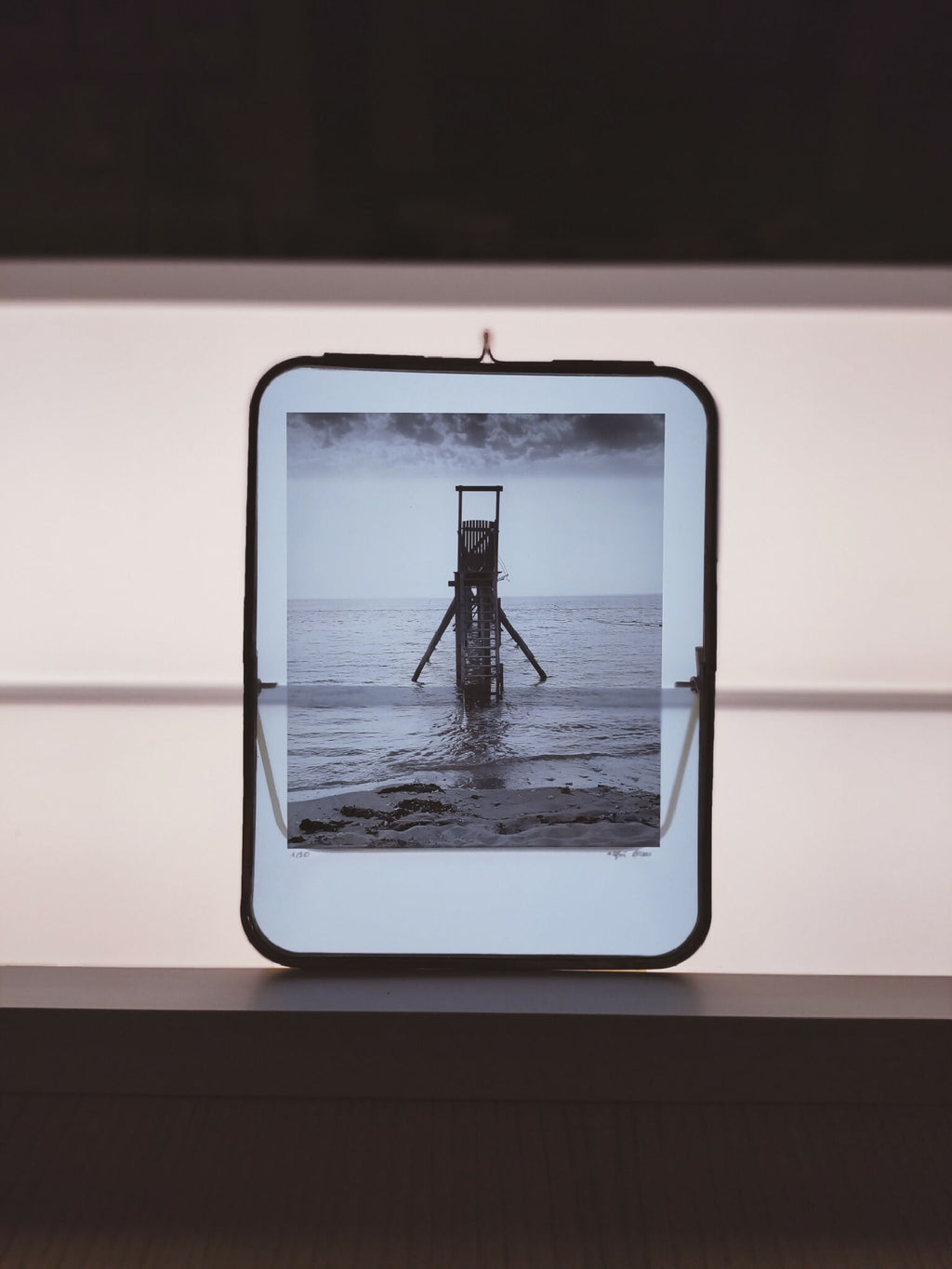 Cadre photo carré avec photo de la mer et plateforme, bord noir, accroche murale