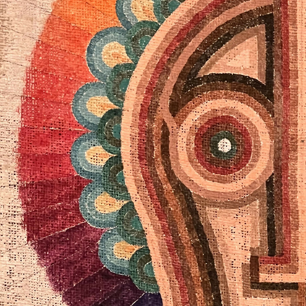 Gros plan sur motif de visage stylisé avec contours ocre, rouge et vert