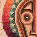 Gros plan sur motif de visage stylisé avec contours ocre, rouge et vert