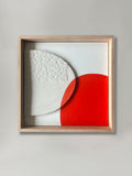 Tableau abstrait en cadre : motif rouge et blanc sur fond clair, formes géométriques