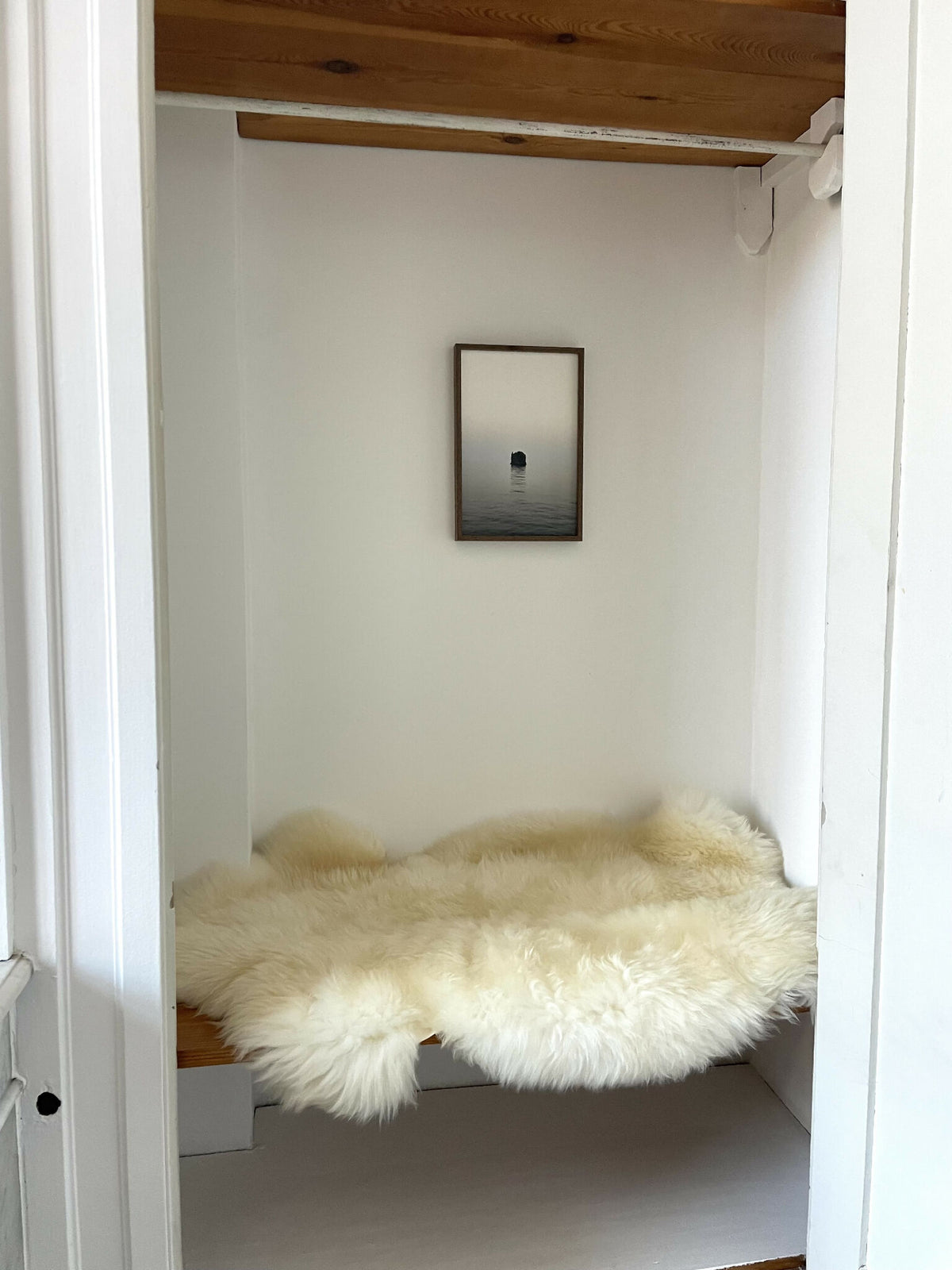 Tapis en fausse fourrure crème, posé au sol dans un renfoncement