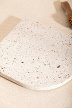 Dessous de plat LIO beige clair moucheté, vue rapprochée de la texture granuleuse