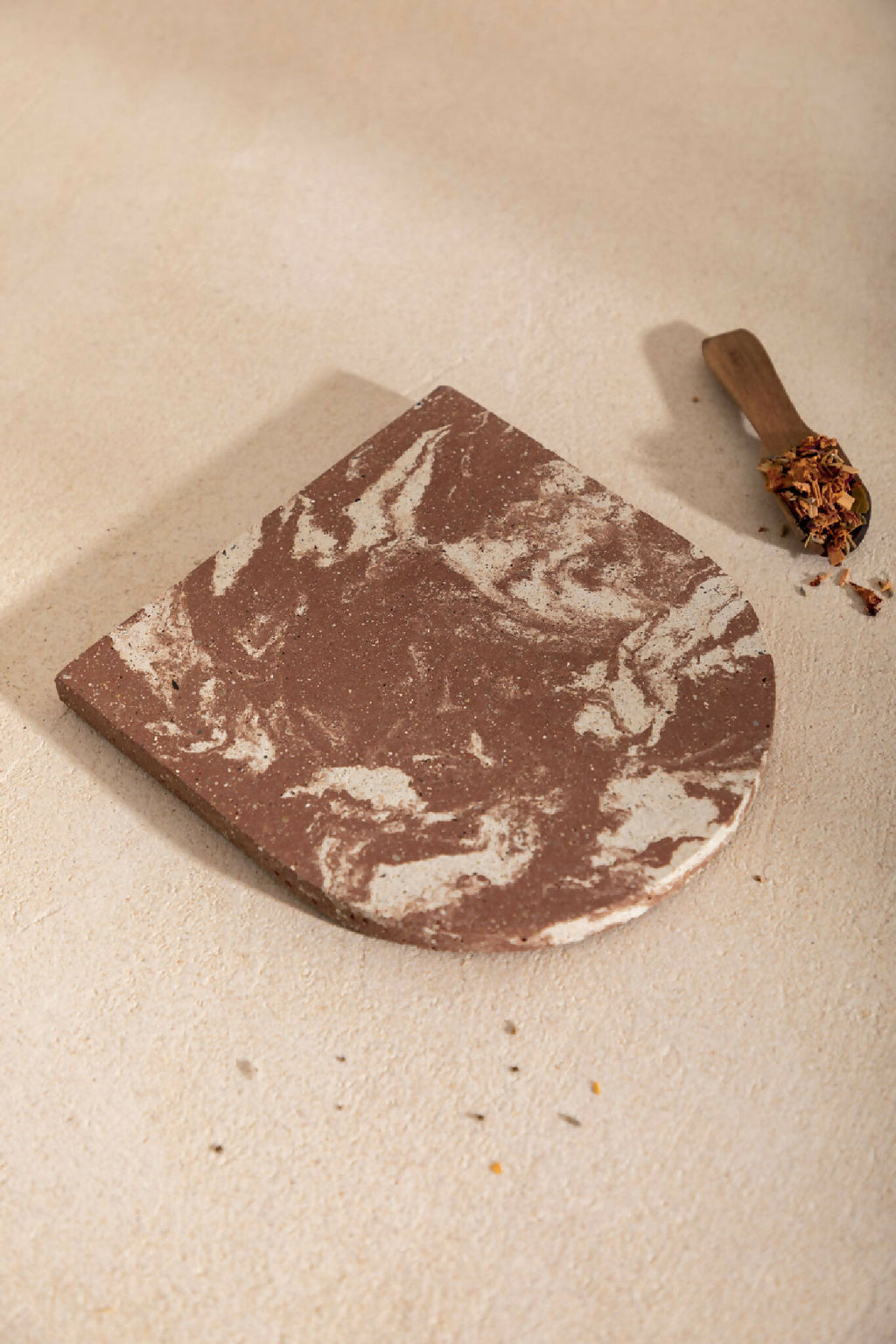 Dessous de plat LIO marron à marbrures blanches, bord arrondi, aspect enduit
