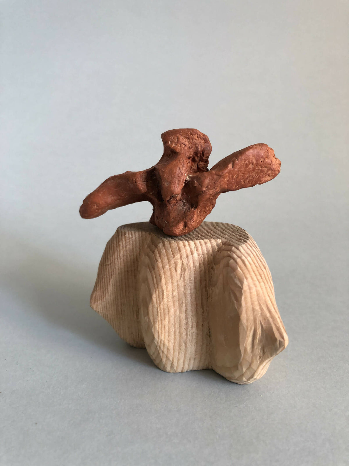 Petite sculpture en métal cuivré sur tissu plissé beige, vue 3/4