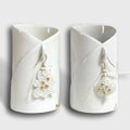 Deux mugs en porcelaine blanche, forme cylindrique, poignées sur le côté