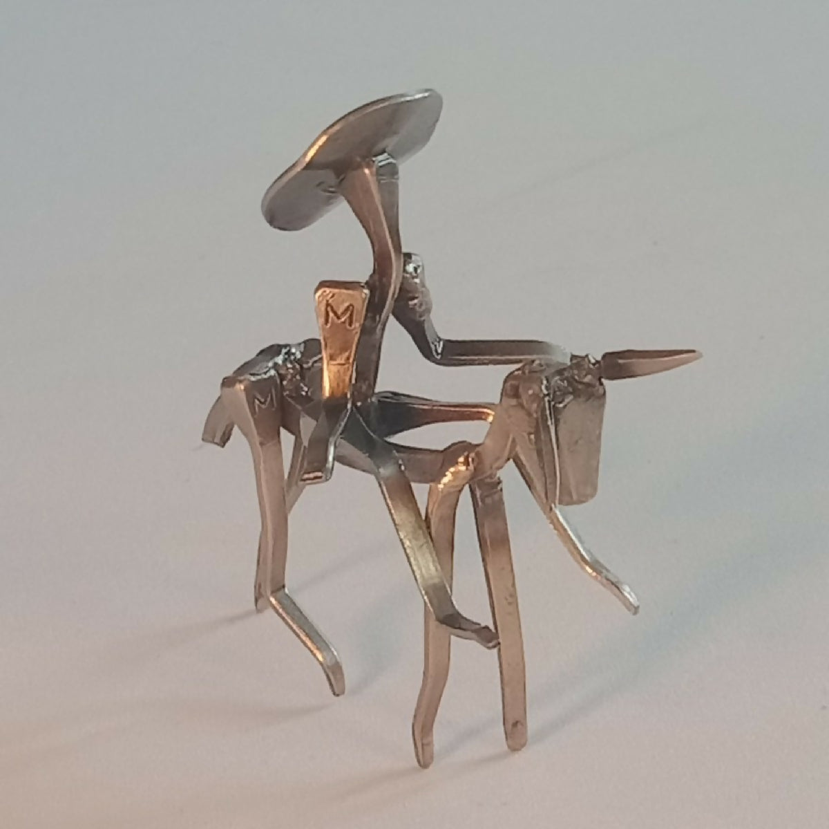Groupe de personnages en acier : chevalier et figurines, finitions argentées.