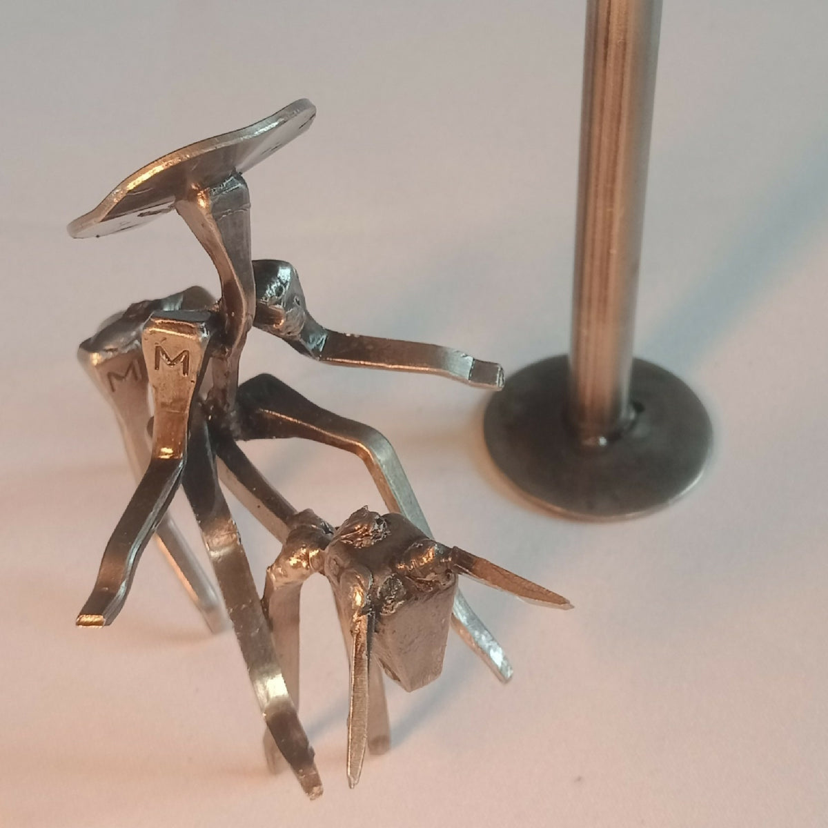 Groupe de figurines en acier : chevalier et personnages miniatures, détails bras et jambes.