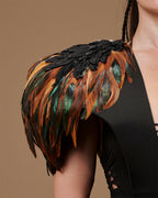 Épaulettes en plumes noires et orange-vert, détail sur l’épaule