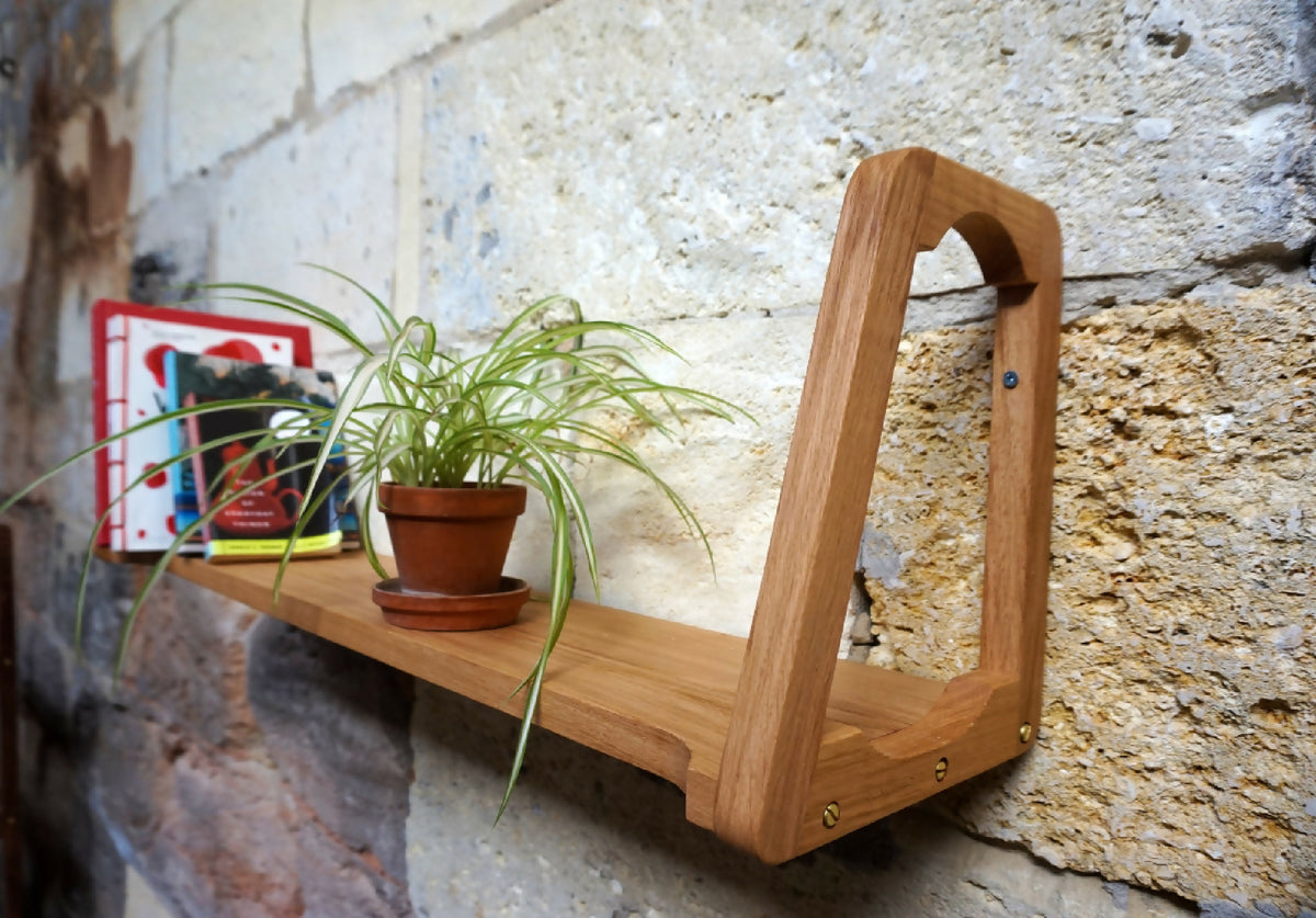 Étagère murale en bois clair avec pot de plante sur la tablette.