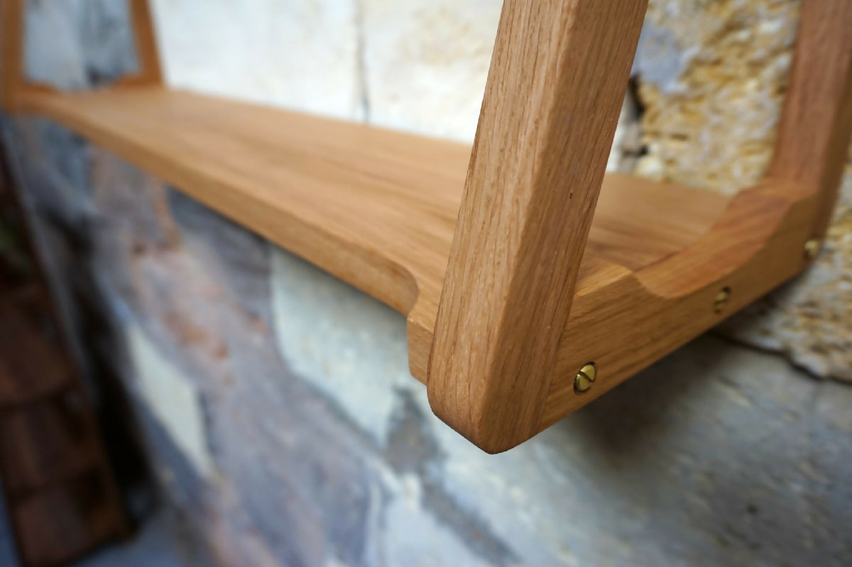 Étagère murale en bois clair, gros plan sur le bord et la fixation.