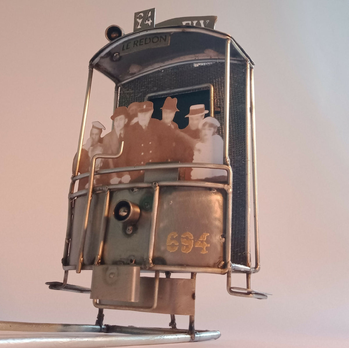 Cabine miniature en métal vue de face, avec numéro «694» et personnages