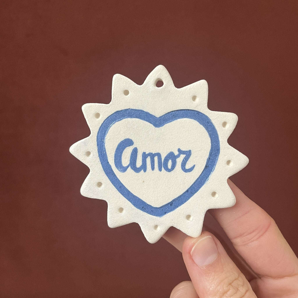 Ex-voto monochrome en étoile, cœur bleu avec le mot « Amor »