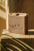 Savon au cacao Fameux en barre rectangulaire brun clair sur plateau en bois