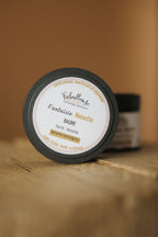 Pot de baume au karité noisette, couvercle noir, étiquette crème, vue de dessus.