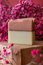 Savon en barre bicolore argile rouge et curcuma, tranche visible sur plateau en bois.