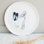 Plat rond en porcelaine blanche fait main, décor abstrait bleu avec éclaboussures.