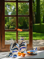 Ensemble de grandes tasses trapèze en céramique blanche, motifs bleu et orange.