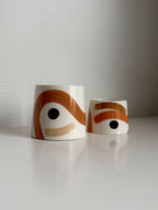 Grande tasse trapèze en céramique blanche, motif brun-orangé, avec petite tasse.